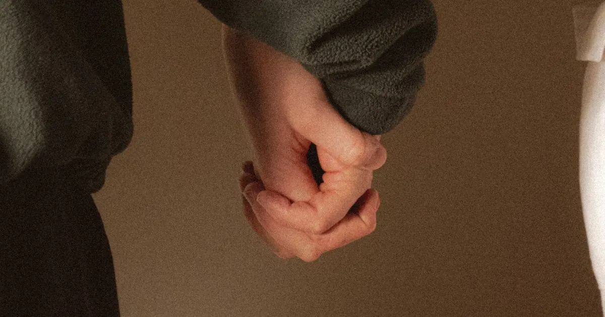 Two people holding hands closely